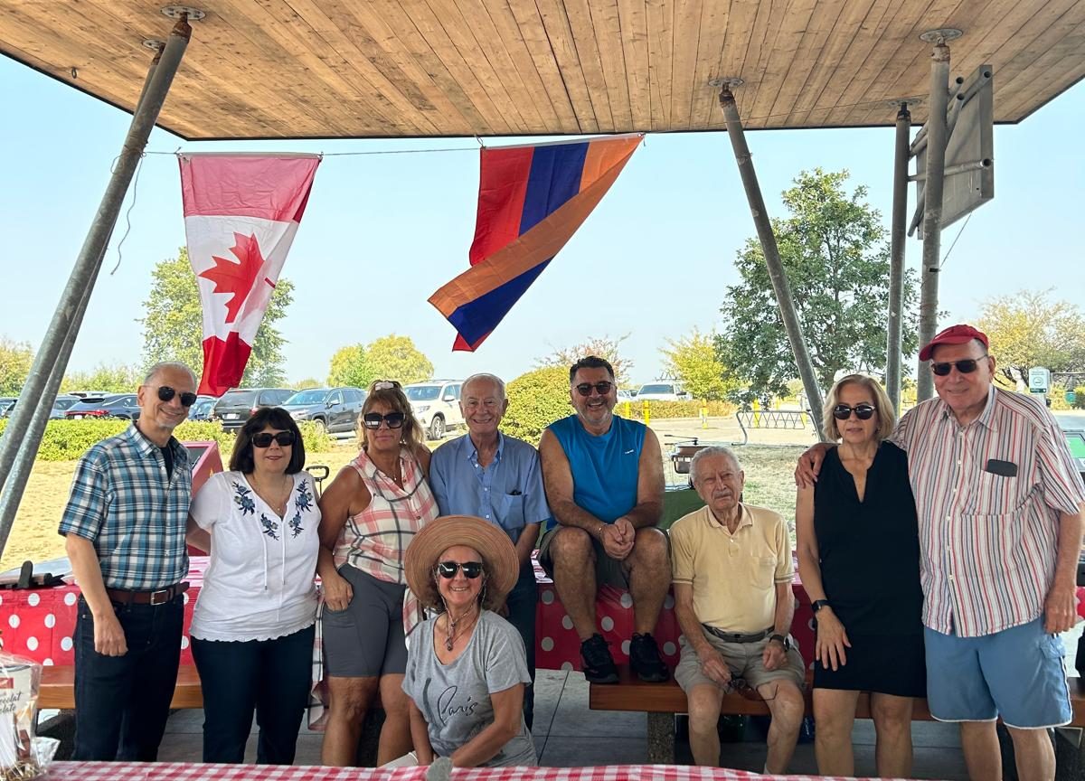 Members of the TCA Vancouver board gathered beneath Canadian and Armenian flags at a community gathering