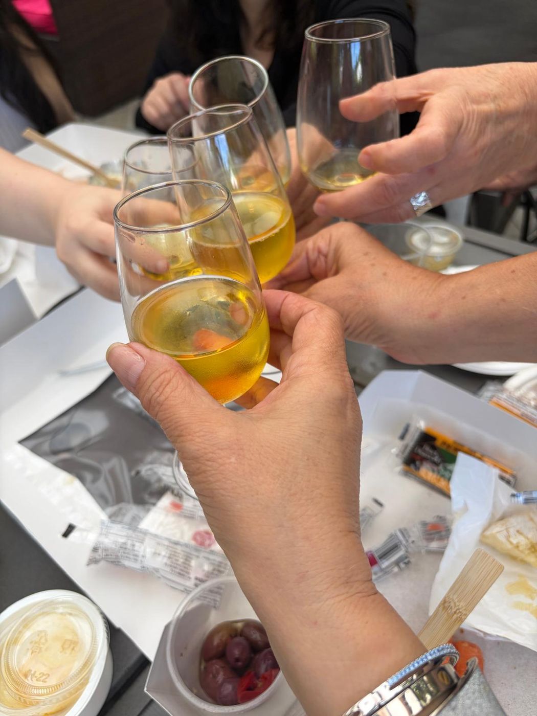 Guests clinking glasses of white wine around the table