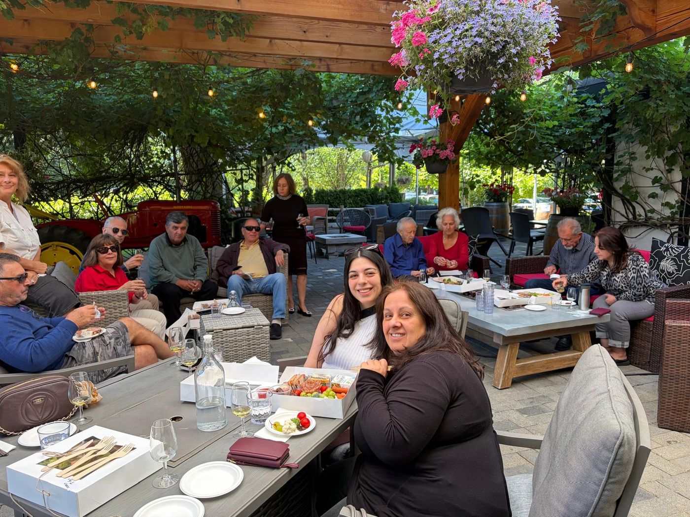 Guests seated across the winery patio with wine and platters